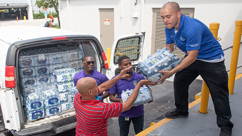 County employees loading a van with packages of bottled water.